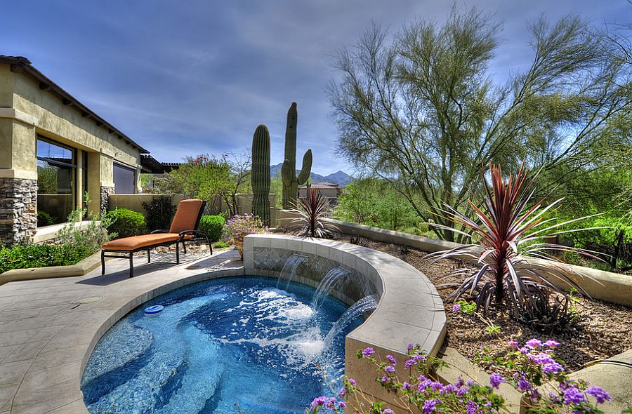 Small round pool with water feature and dessert landscaping.