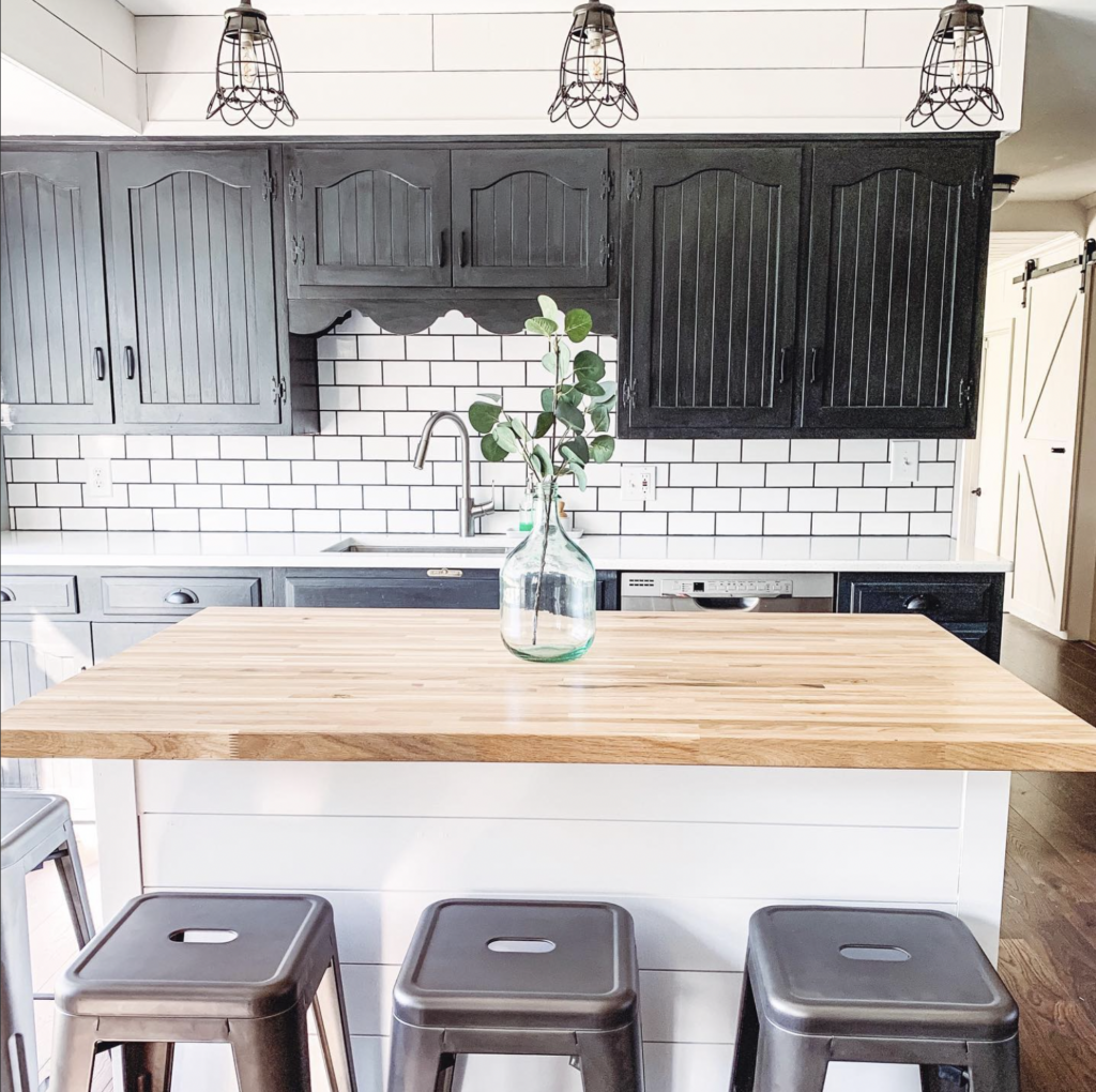 A black cabinet wall with subway tile behind it