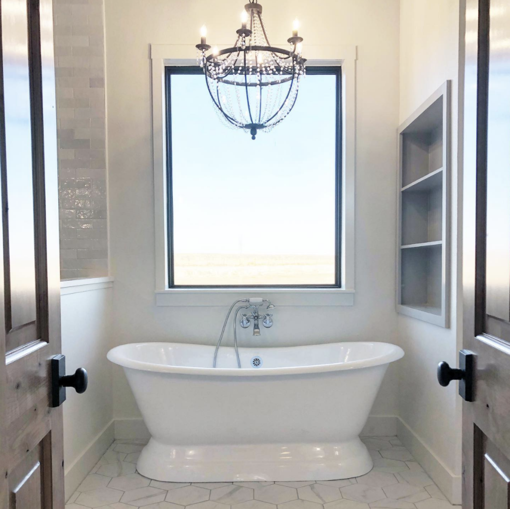 A black chandelier for bathrooms with hexagon tile, sleek in style