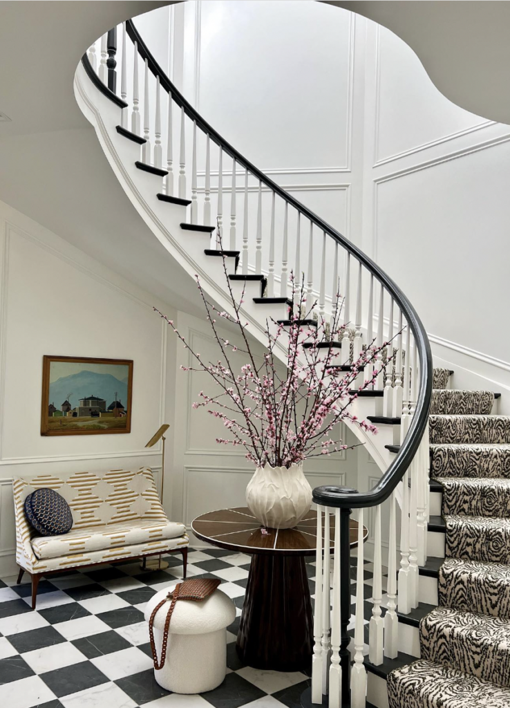 A Carpet Runner with Animal Print Covers the Black and White Stairs