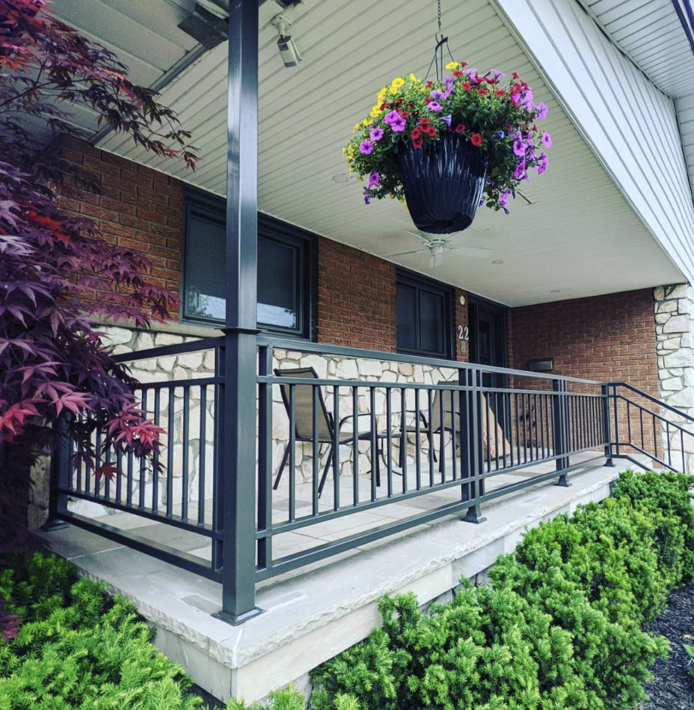 A Porch with Metal Railing and Grey Stone Tile