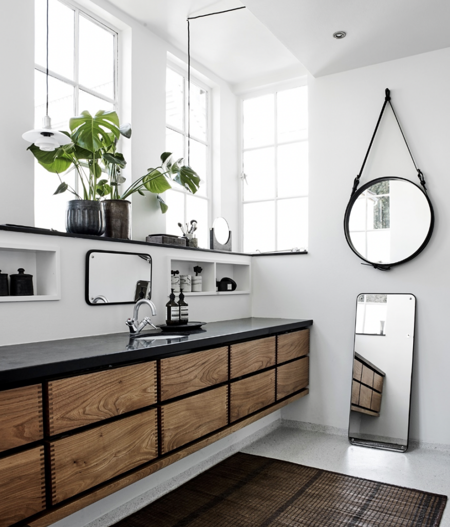 A White Bathroom Contains Large Windows with a Black Countertop and Sink