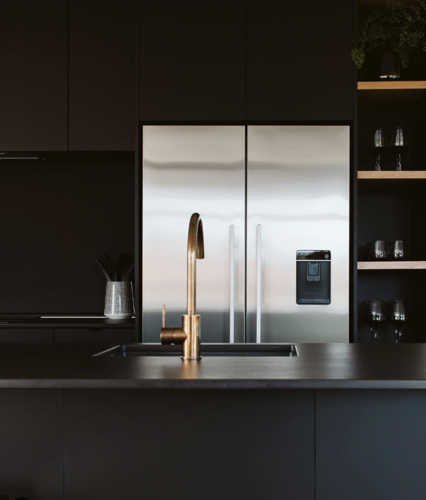 Above the Refrigerator Are a Black Matte Cabinet and Floating Shelves