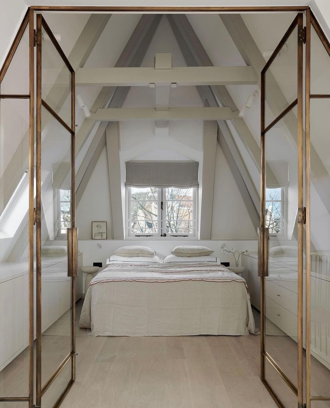Attic Bedroom with Glass Doors and Reflective Surfaces