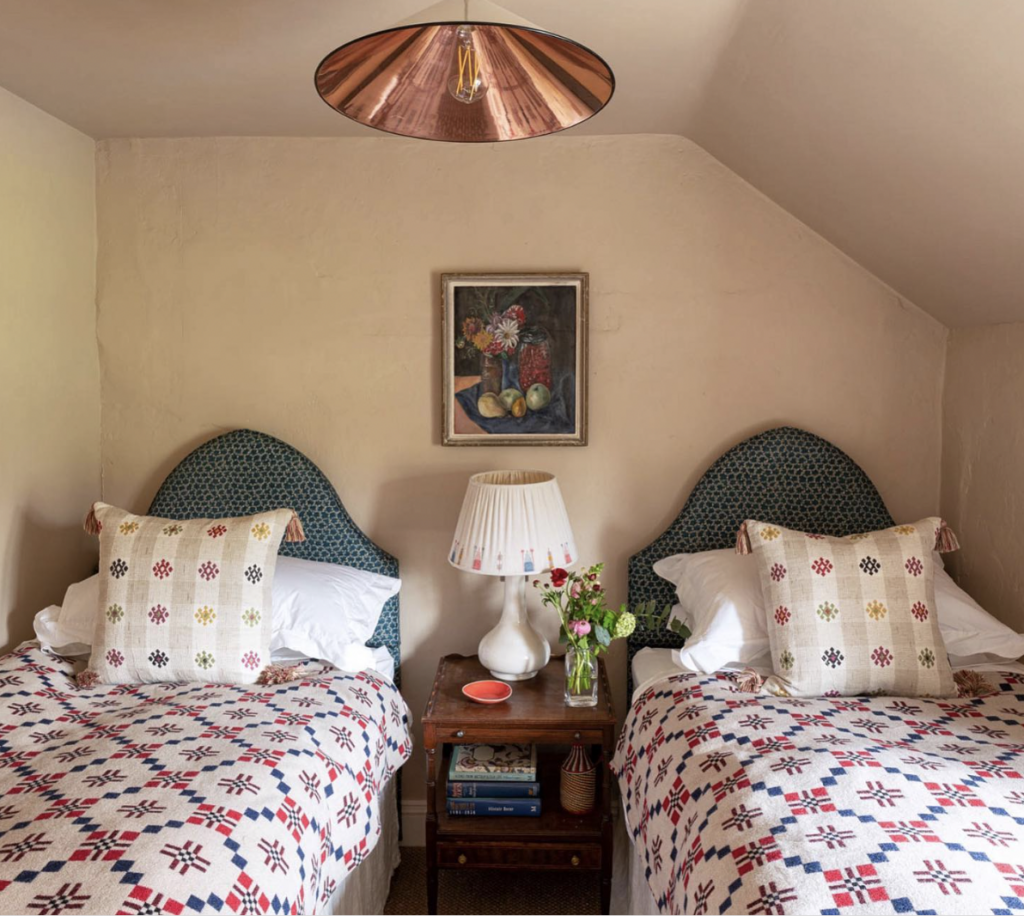 beds with green headboards in a small bedroom