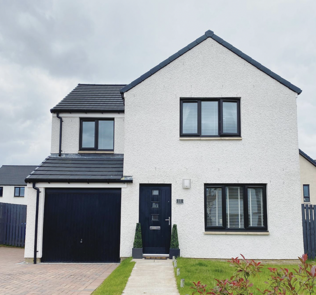 Beige House with Black Door and Roof