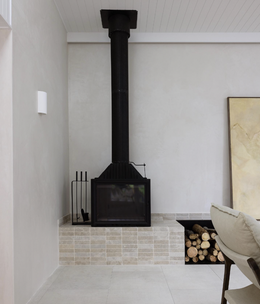 Black Fireplace Fueled by Gas Over a Beige Tile Hearth