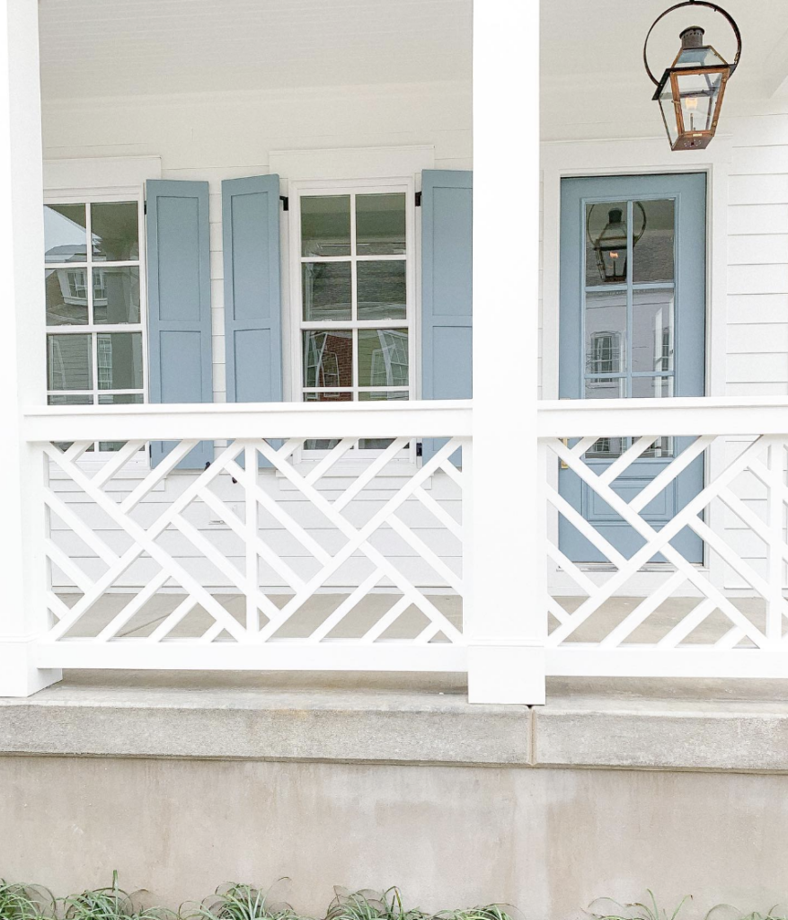 Blue front door beside the white deck railing