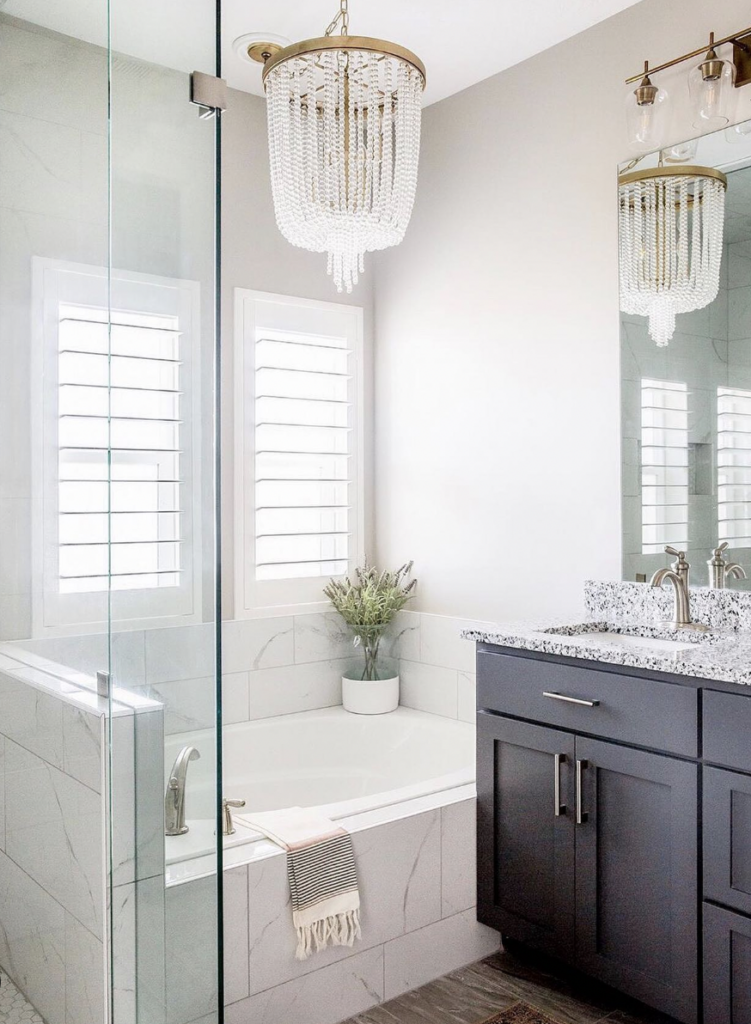 Crystal Chandelier Paired with Sconces in a Small Bathroom