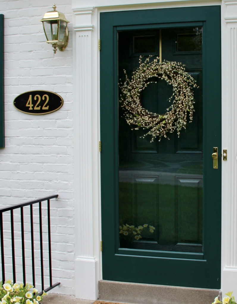 Dark green modern front door adorned with a wreath