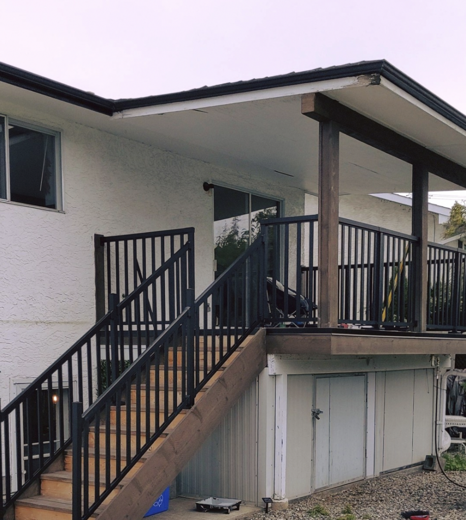 Dark wood flooring beside a black porch railing