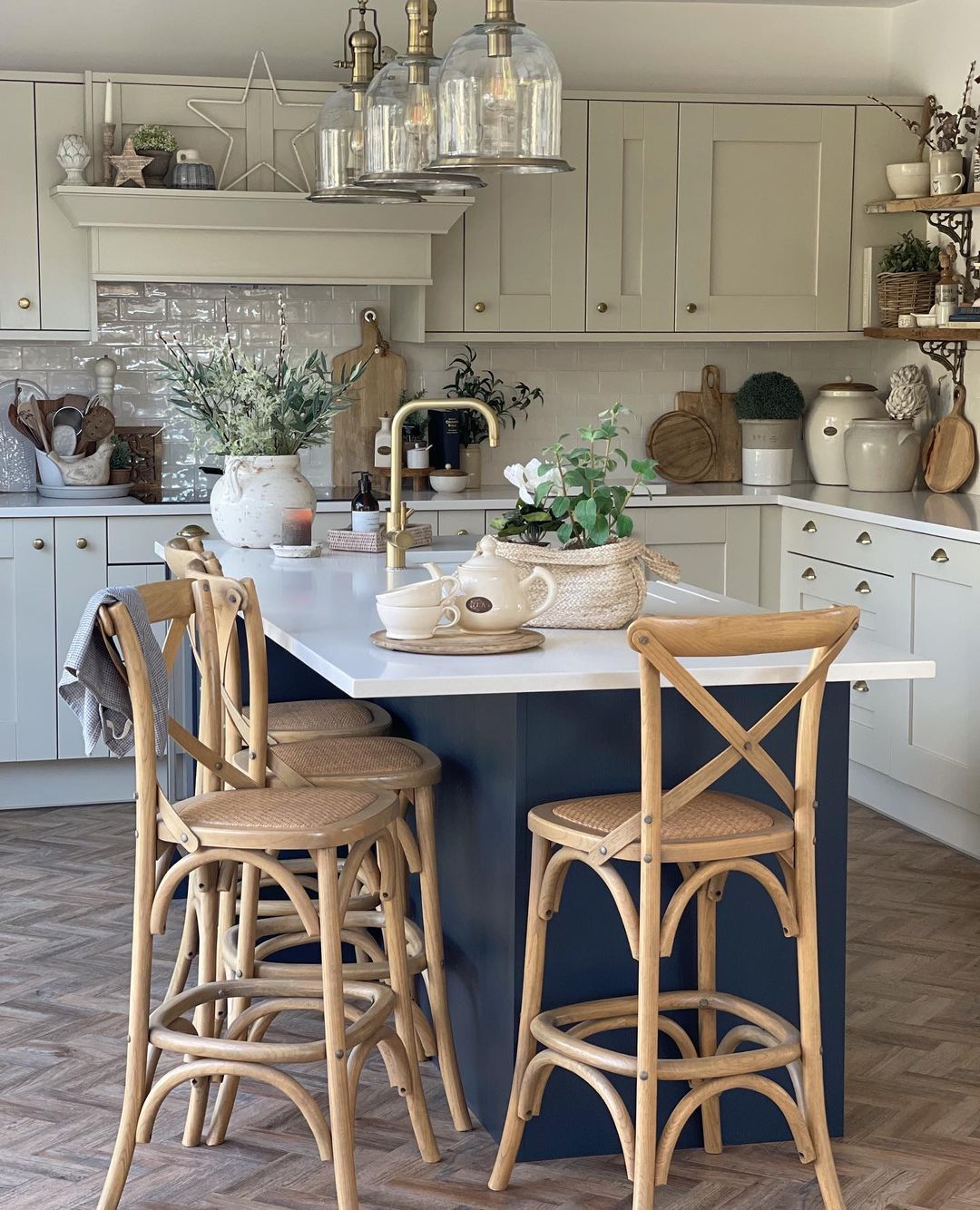 Navy island with bentwood stools, glass pendants, and natural textures
