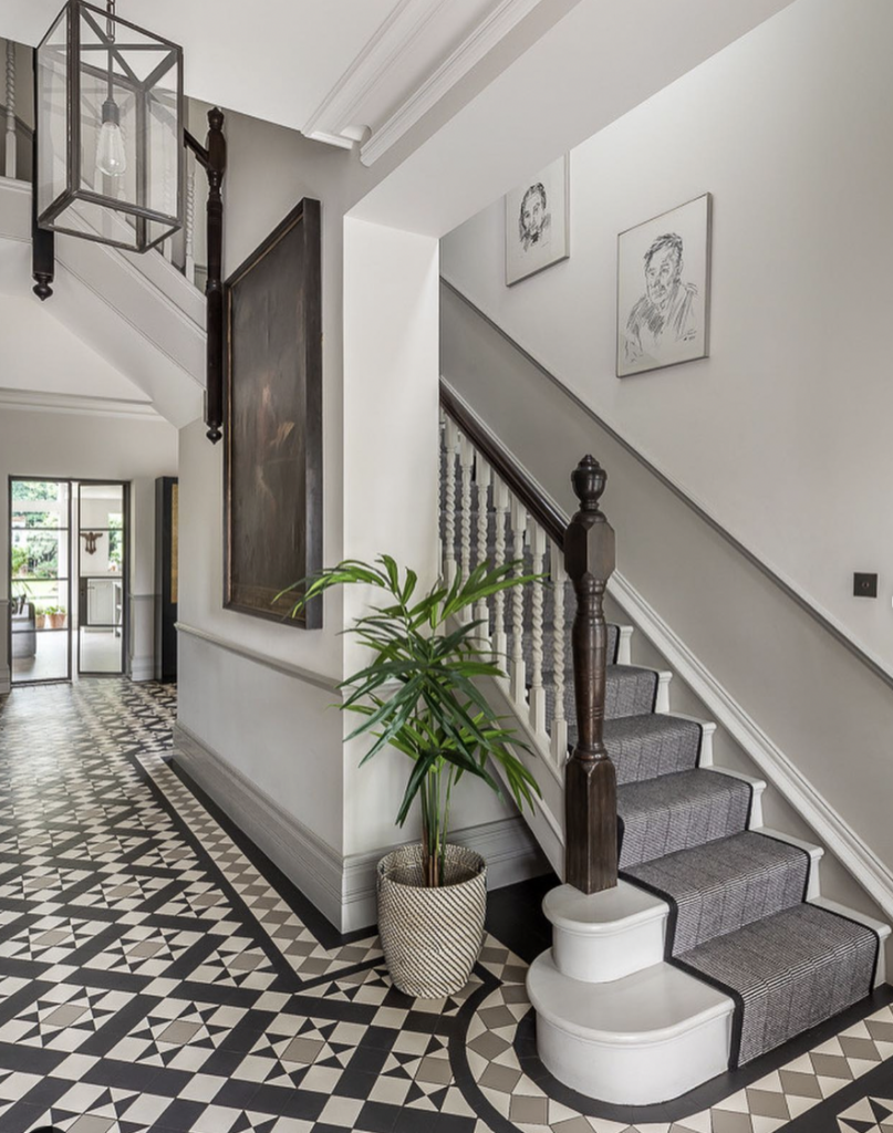 Entryway Wood Elements Around a Black Arched Door with Checkerboard Flooring
