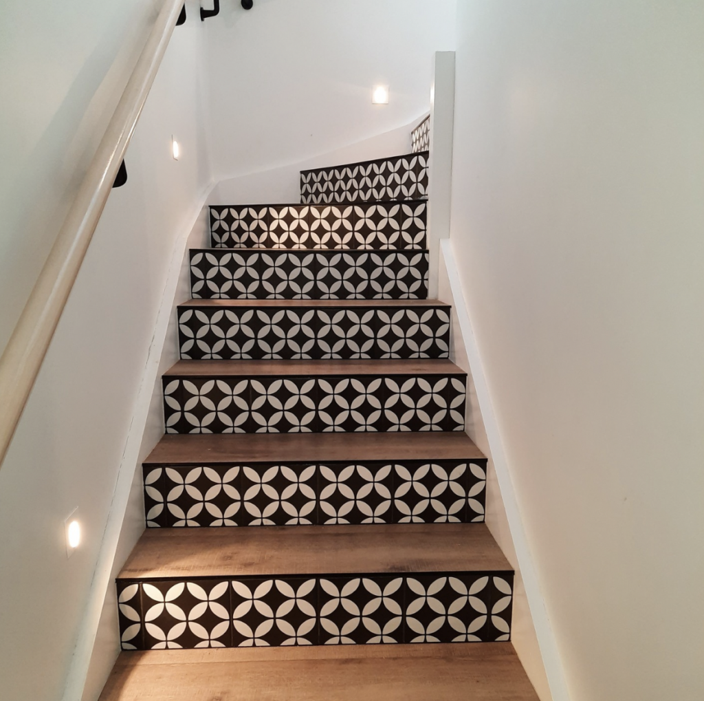 Floral riser tiles in black and white above wood steps