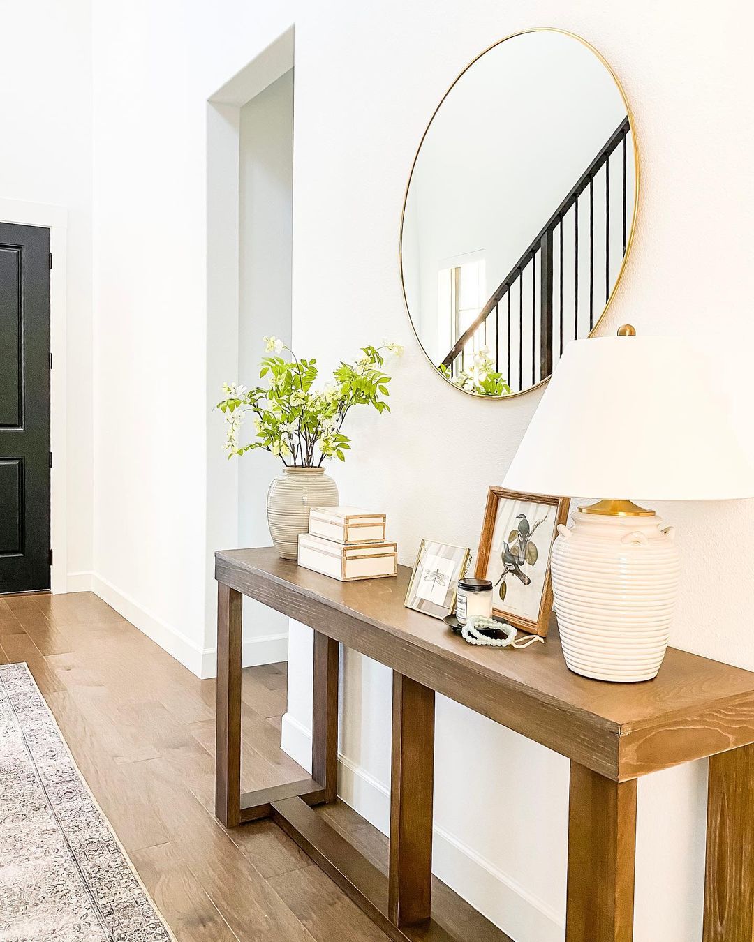 Gold Oval Mirror Above Slender Dark Wood Console