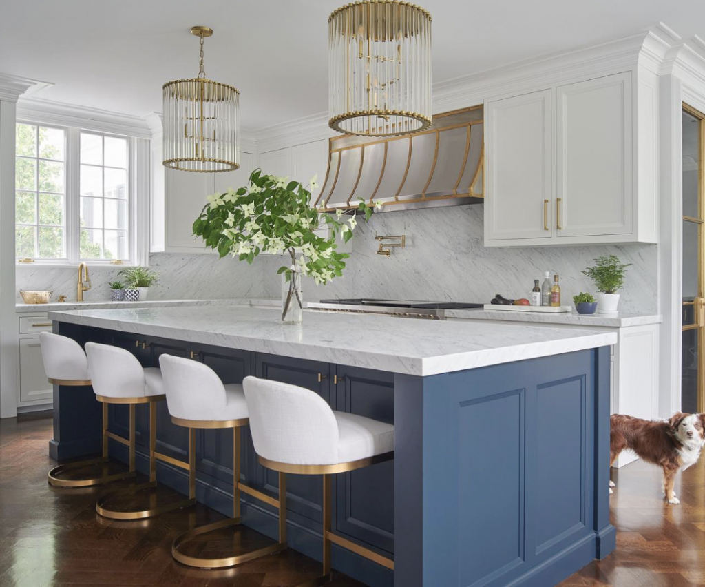 Gold Vent Accenting a White Kitchen and Navy Blue Collar Island