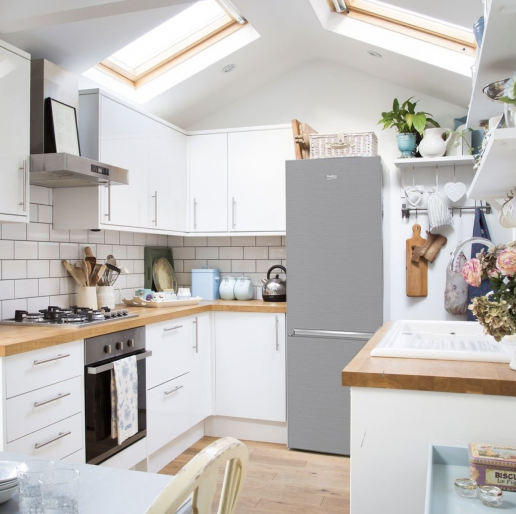 Grey fridge in a white kitchen with a wood countertop