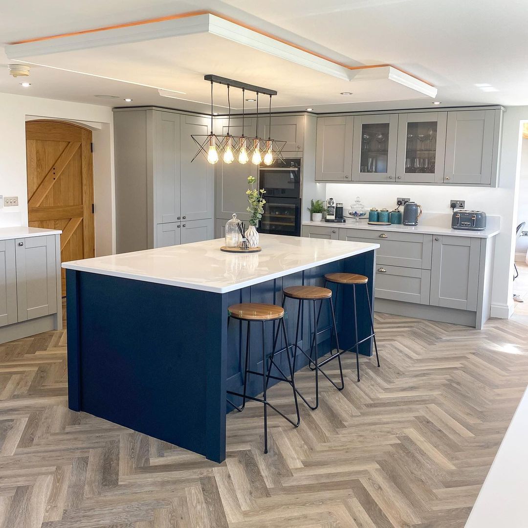 Navy island against herringbone floor with industrial light fixture
