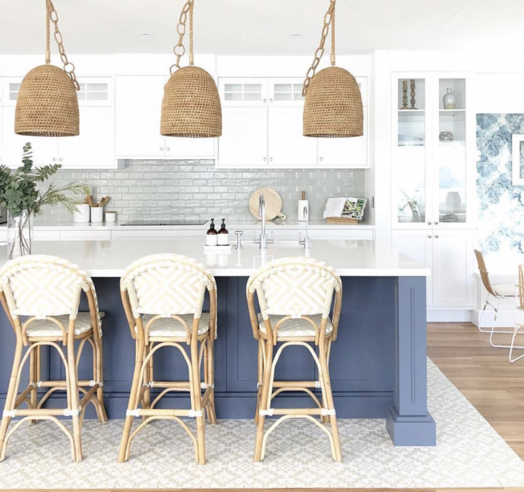 Kitchen with a gray backsplash and blue cabinets