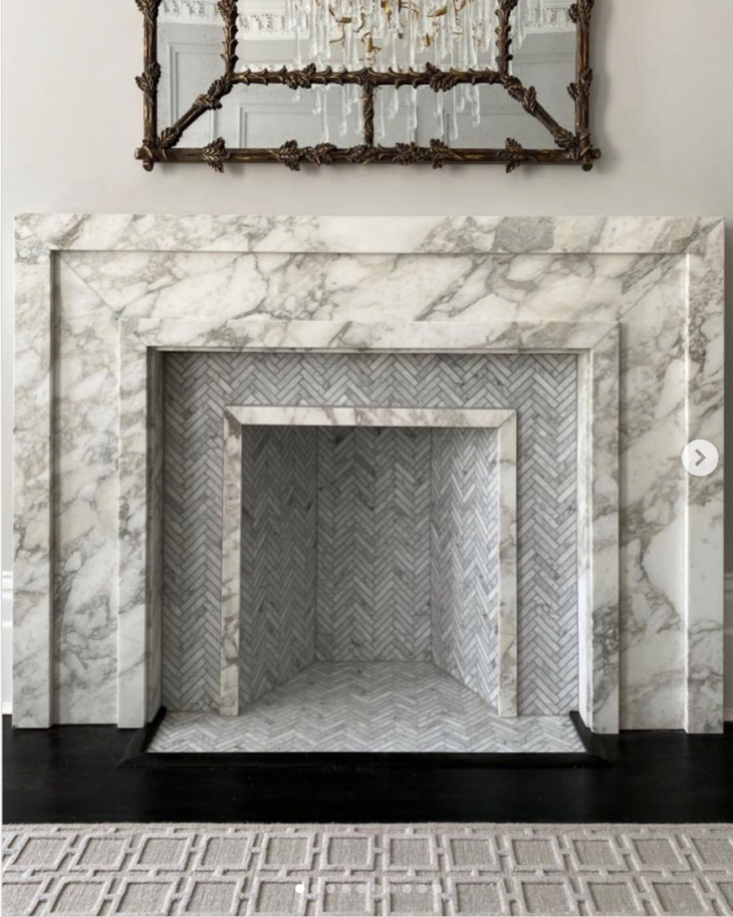 Marble fireplace and its tile hearth in a herringbone pattern