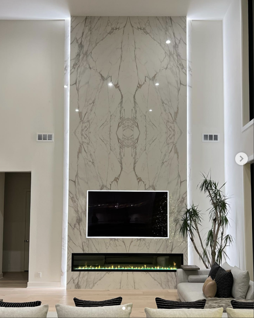 Electric fireplace with TV above on marble accent wall