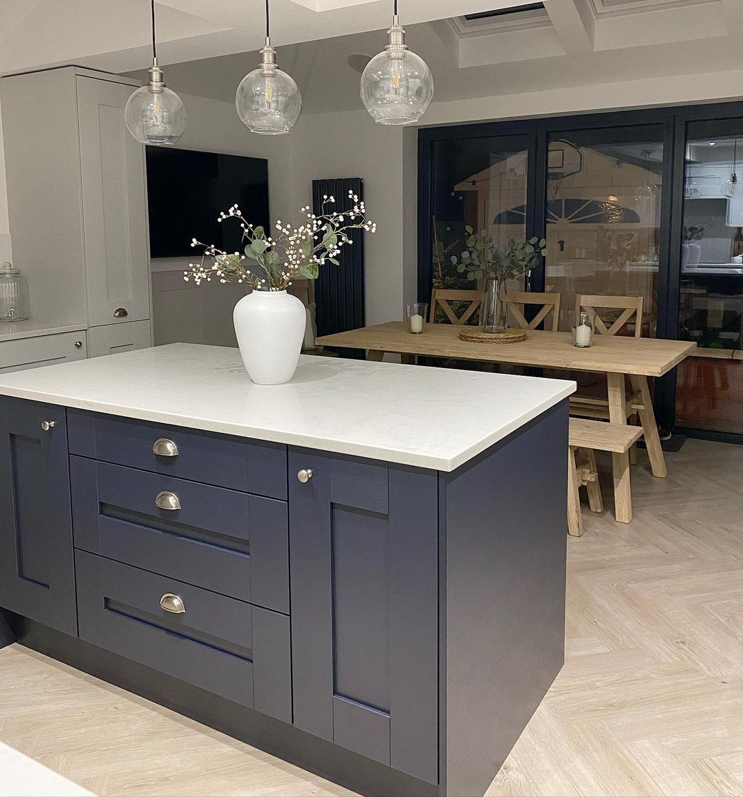 Minimalist navy island with silver hardware and glass pendant lights