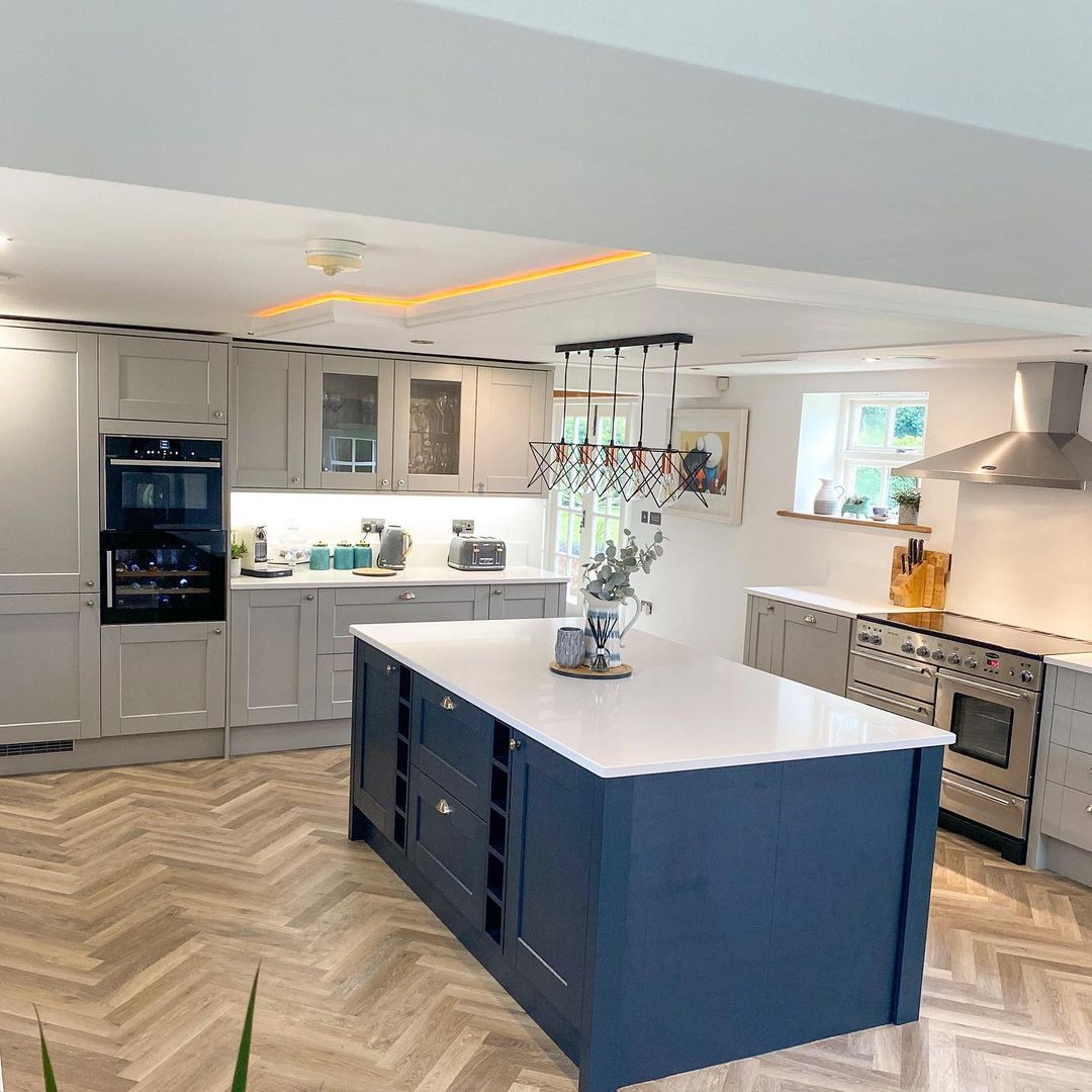 Navy island with minimalist stools and geometric light fixture
