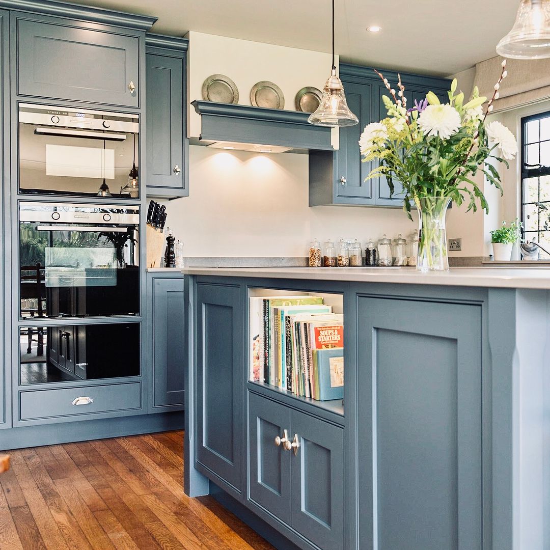 Navy island kitchen with glass-fronted cabinets and under-cabinet lighting