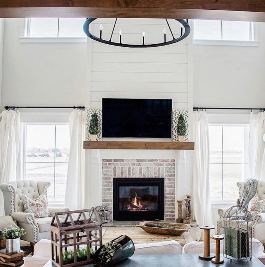 Shiplap wall with a red brick fireplace mantel