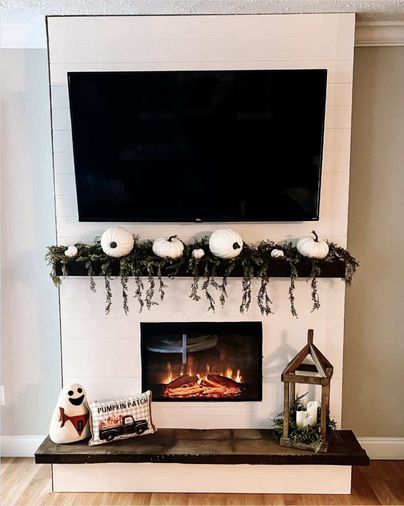 TV Above a Built-In Fireplace on a White Wall
