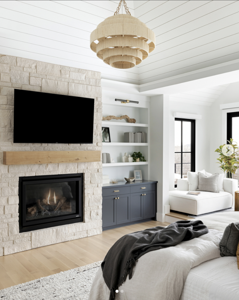 Stone accent wall with electric fireplace and TV above