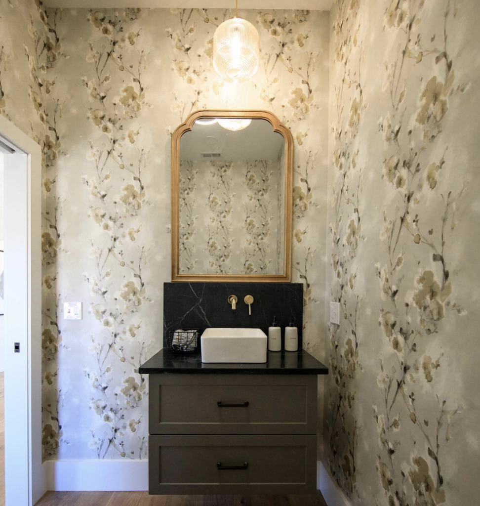 Vanity with Black Countertop and Gold Mirror