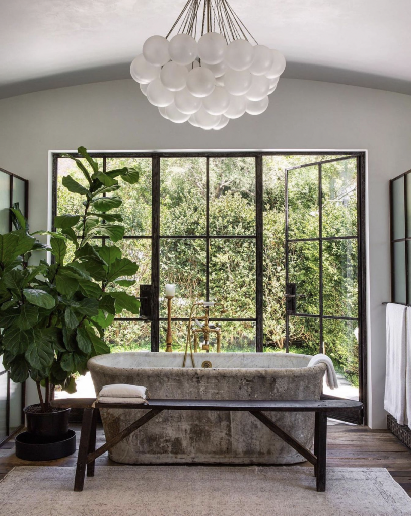 White Chandelier Above a Freestanding Stone Bathtub